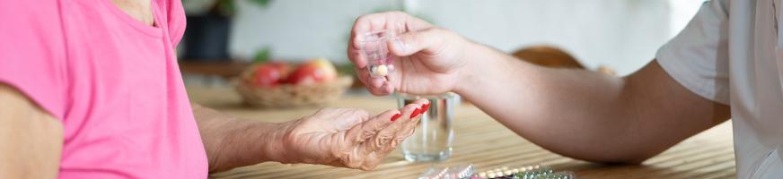 Infirmier remettant des médicaments à une patiente à domicile