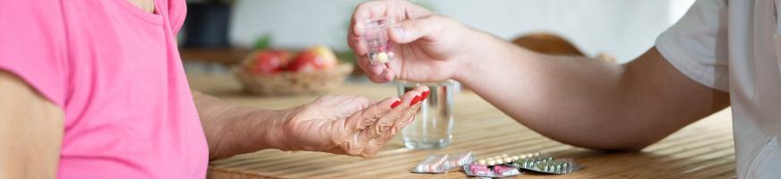 Infirmier remettant des médicaments à une patiente à domicile